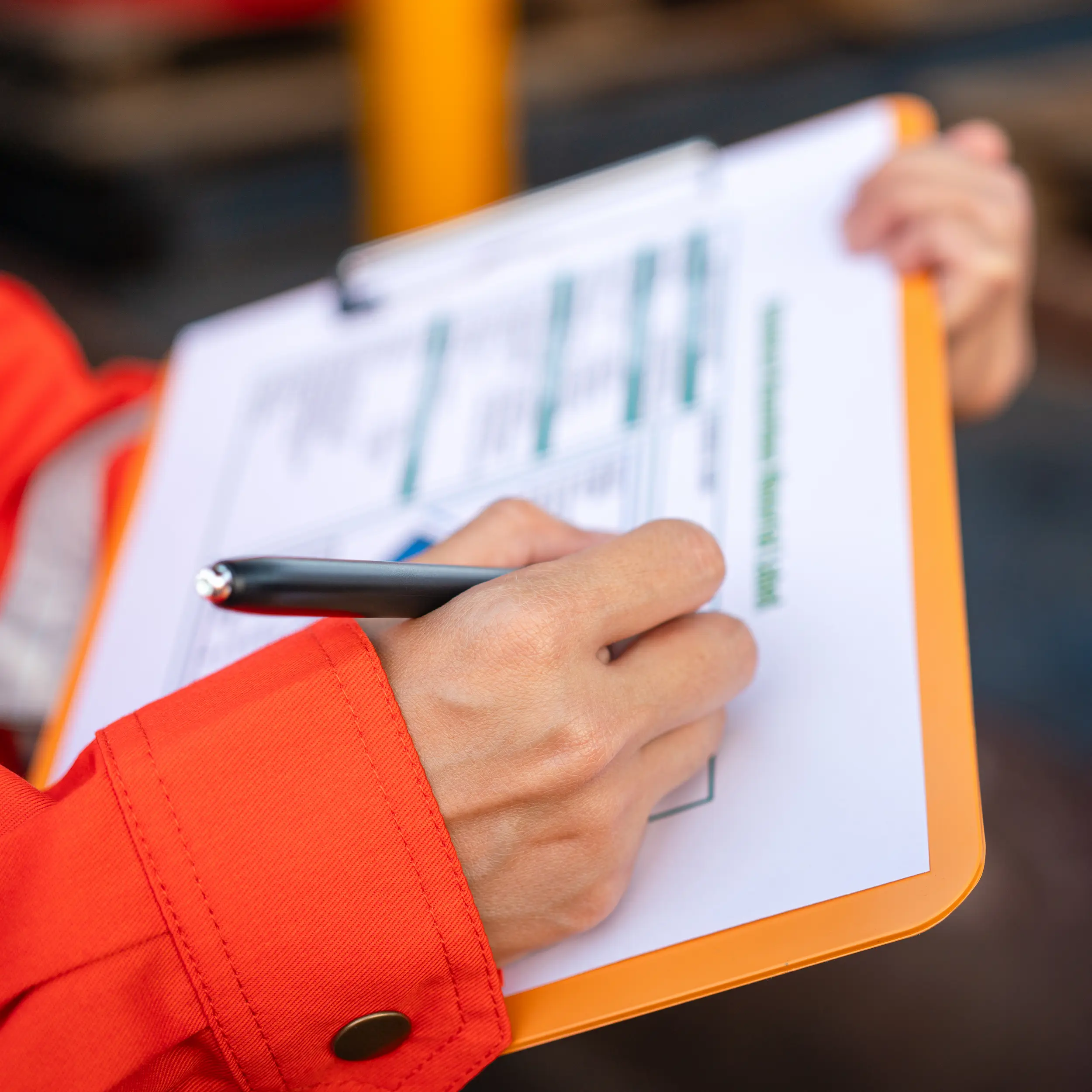 safety-officer-is-checking-hazardous-material-checklist-form-with-chemical-storage-area